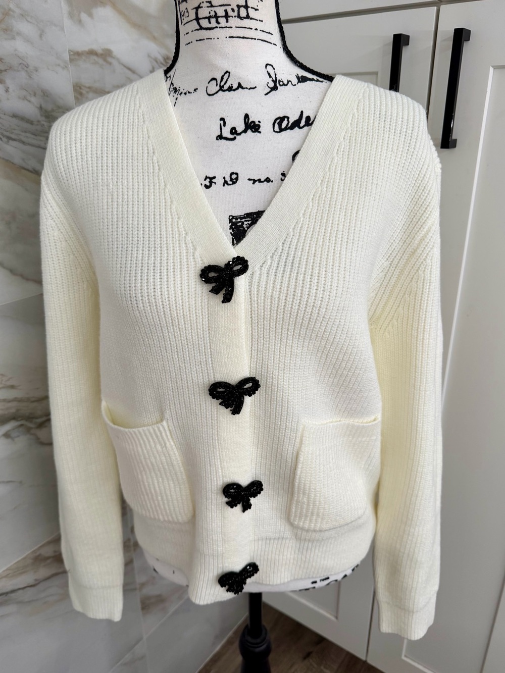 Astr Cream V-Neck Cardigan with Black Bow Buttons